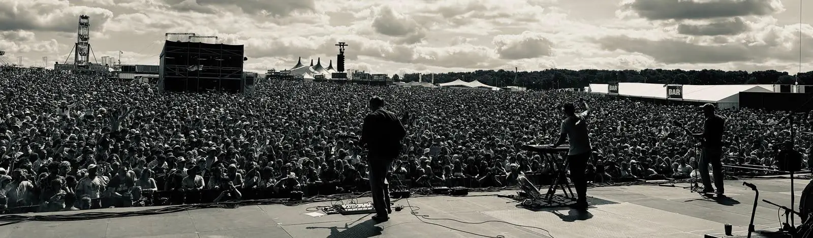 View from the stage across a huge festival crowd, black and white